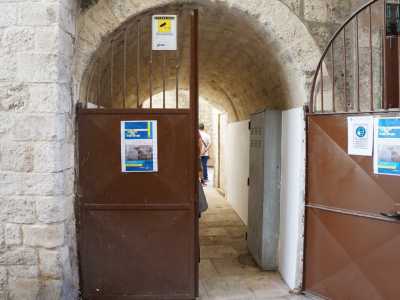 Qui infatti � collocata una pesante porta in ferro marrone inquadrata da un�arcata litica...